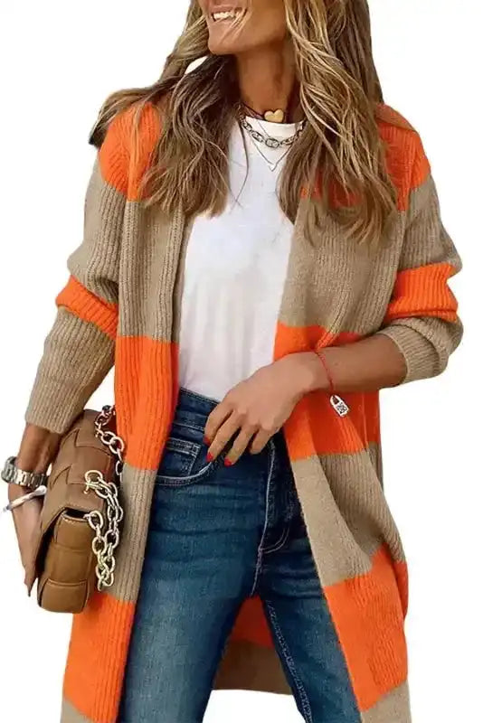 Chic orange cardigan with beige colorblock ribbed knit, styled with jeans and a white tee for a modern fall-to-winter look.