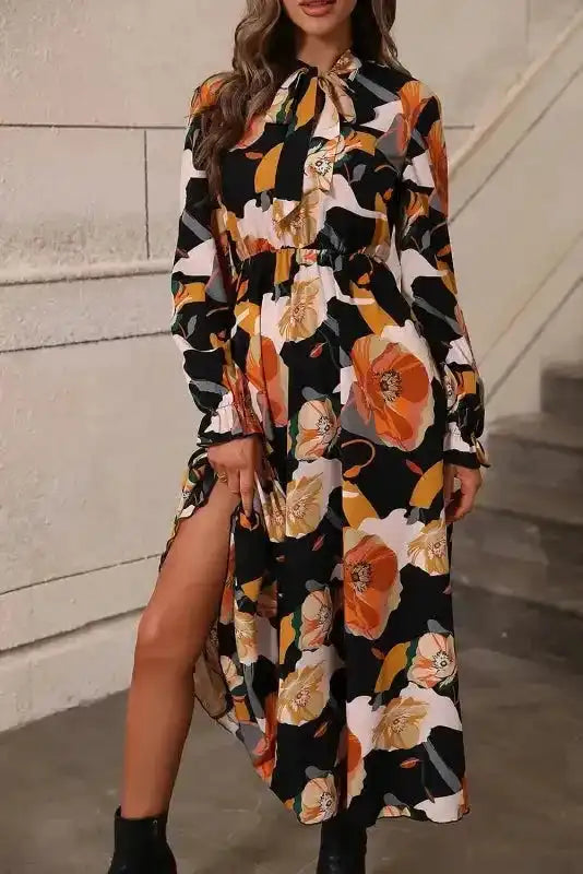 Orange floral tie neck dress with long sleeves and side slit, ideal for daily or holiday wear in a soft, flowing fabric.
