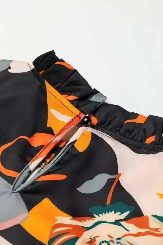 Back neckline with button closure on Orange Floral Tie Neck Dress, featuring ruffle trim and colorful floral design.