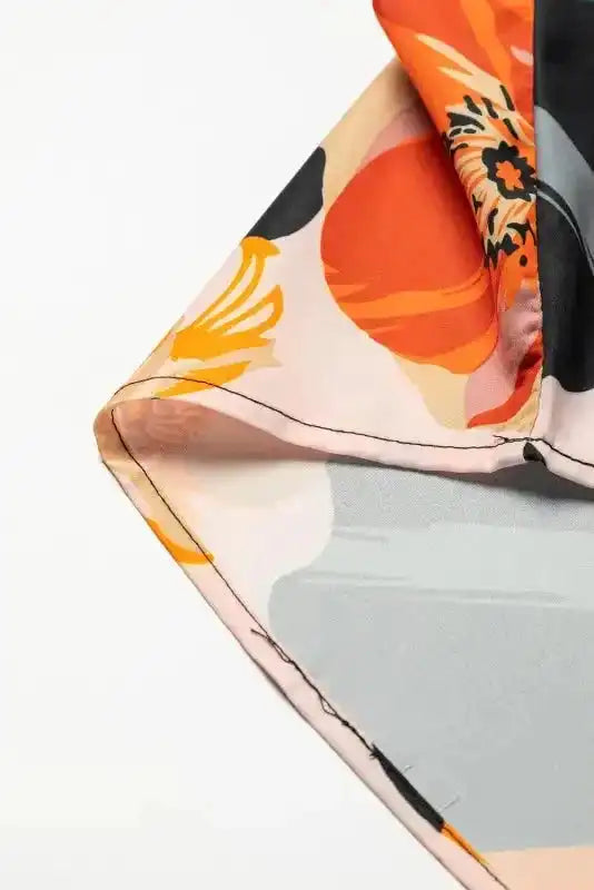 Hem detail of Orange Floral Long Sleeve Dress with smooth stitching and bold floral pattern, ideal for casual or holiday outfits.