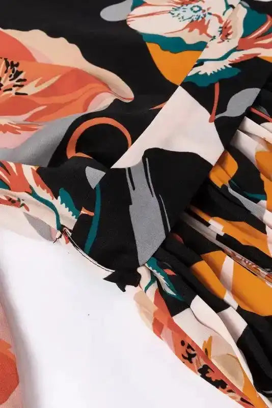 Detail of waist seam and pleats on Orange Floral Long Sleeve Dress, highlighting high-quality stitching and bold floral design.