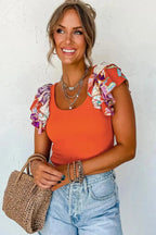 Close-up of orange ribbed knit bodysuit with colorful ruffled sleeves, accessorized with gold jewelry and a woven handbag for a trendy summer vibe.