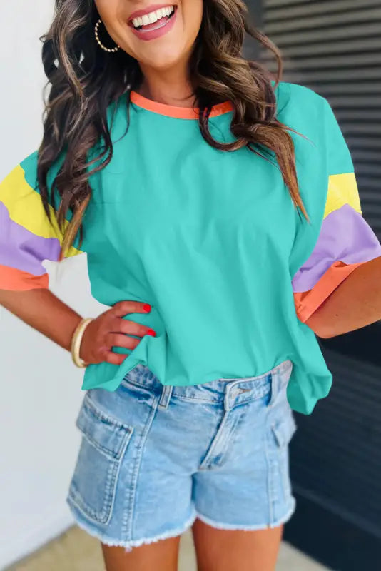 Oversized stitched top: colorful turquoise t-shirt with striped sleeves and denim shorts