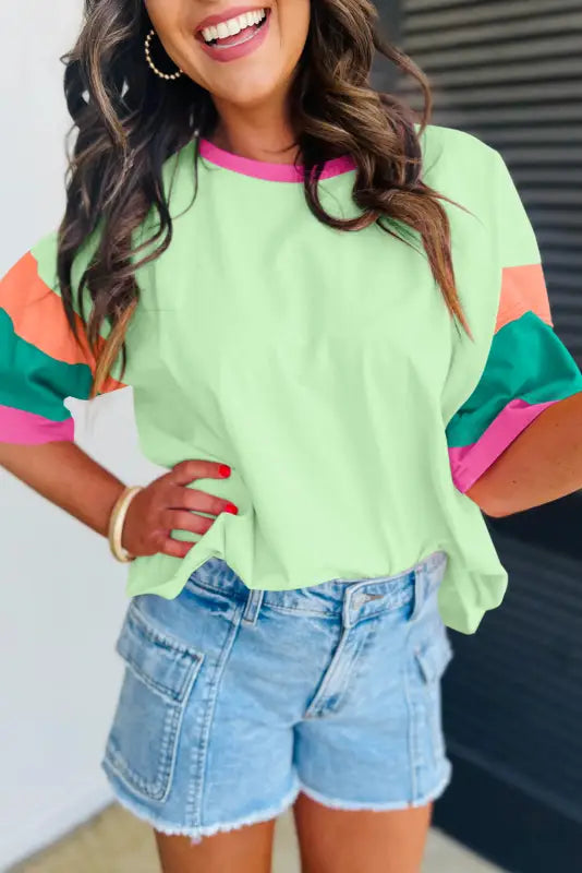 Oversized stitched top: colorful pastel green sweater with vibrant sleeves & denim shorts. Relax!