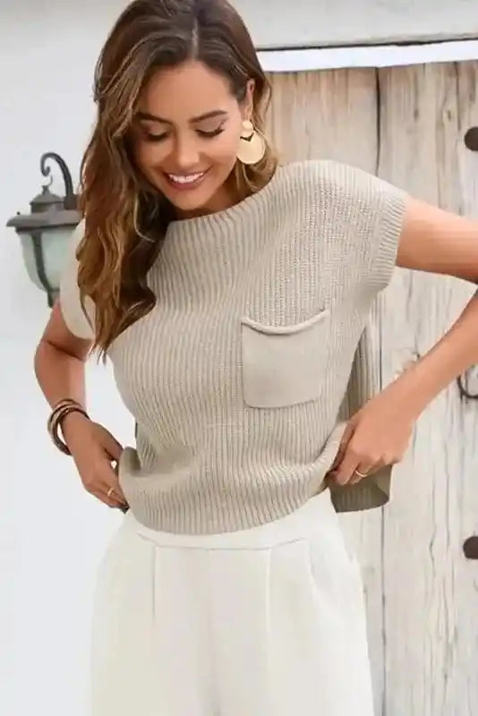 Woman adjusting Pale Khaki Patch Pocket Short Sleeve Sweater, highlighting its soft ribbed fabric and relaxed fit.