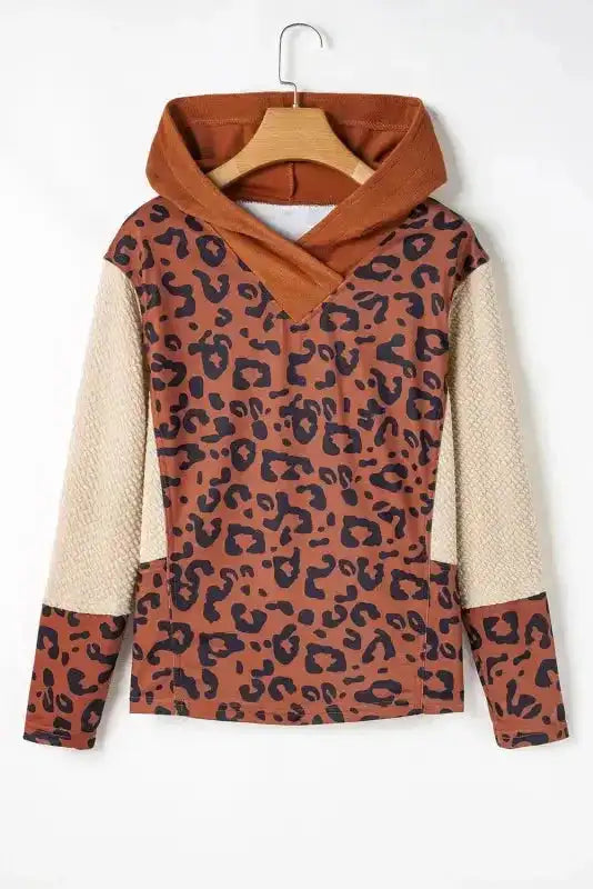 Flat lay of Patchwork Leopard Hoodie Oversized Textured Knit showing detailed animal print, waffle-knit sleeves, and hooded neckline.
