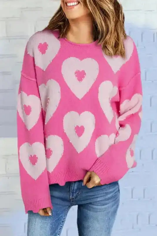 Bright pink heart-patterned sweater with light pink hearts, styled with jeans for a casual Valentine's Day look.