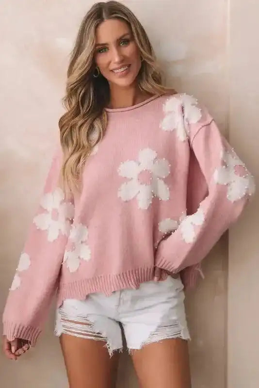 Front view of the Ladies Pink Pearl Beaded Floral Sweater by FashionFitz paired with white shorts, showcasing floral bead design.