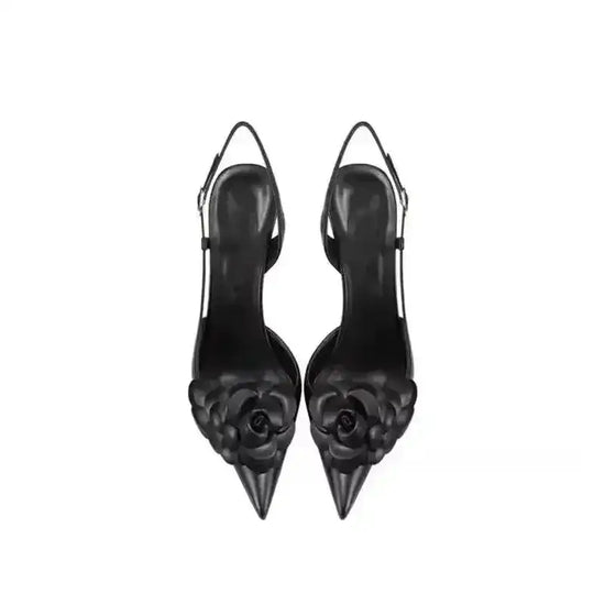 Top view of black Petal Pirouette Slingback Heels showcasing pointed toes and 3D floral embellishments, stylish and elegant.
