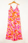 Pink boho jumpsuit: wide leg abstract print in pink, orange, and red on wooden hanger