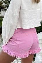 Rear angle of ladies pink denim shorts with frayed hem, showcasing stretch cotton fit for daily summer styling.