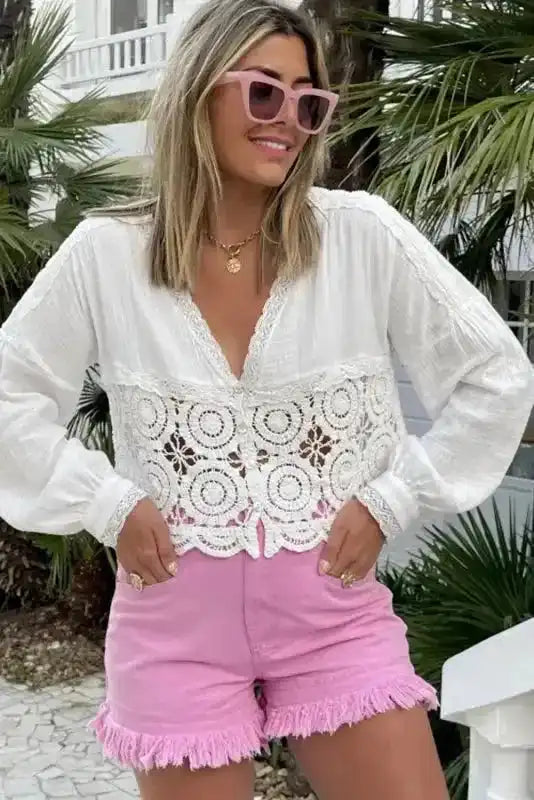 Woman wearing pink mid rise denim shorts with frayed hem and stretch cotton, styled for summer festival fashion.