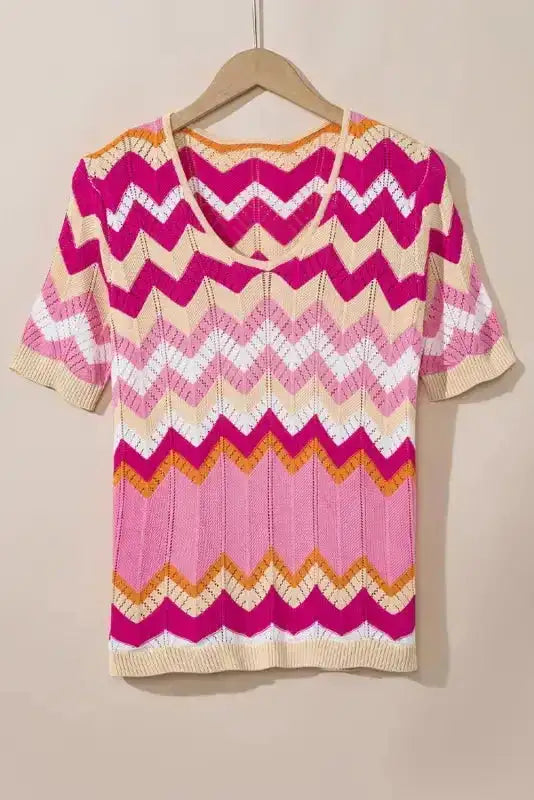 Pink chevron crochet jumper on hanger showing short sleeves and colorful zigzag knit. A breathable, feminine summer knit top.