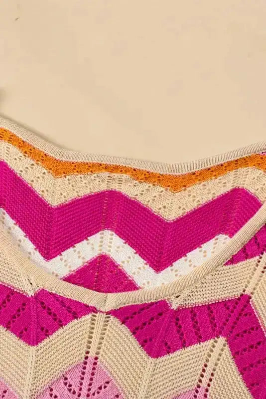 Neckline detail of pink chevron crochet jumper with orange and beige zigzag trim. Scoop neck design enhances feminine summer style.
