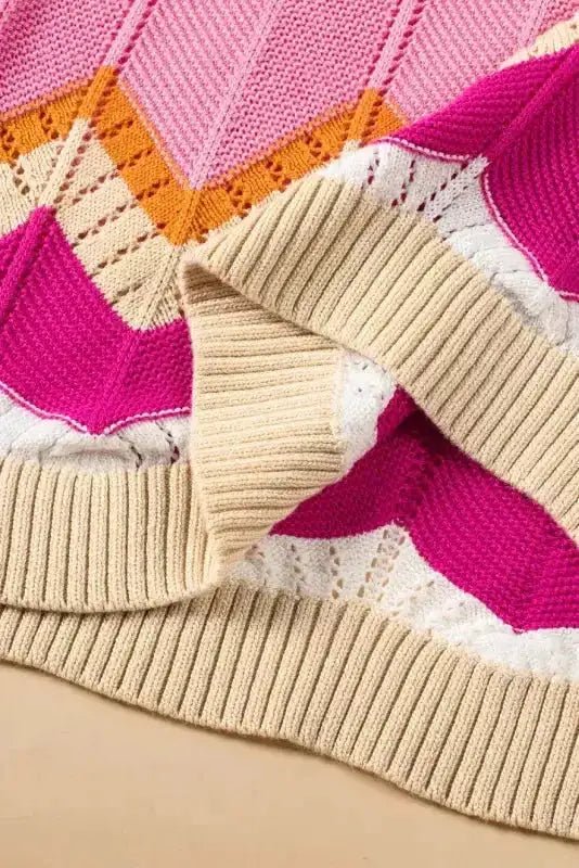 Close-up of hem detail on pink chevron crochet jumper with ribbed knit finish. Soft and stretchy for comfortable summer wear.