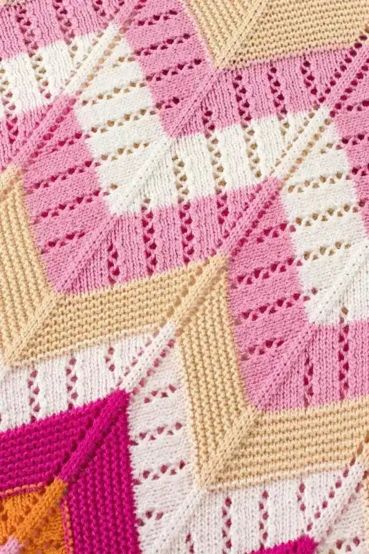 Detailed view of pink chevron crochet jumper fabric showing openwork knit and color block pattern. Lightweight and textured for warm weather.