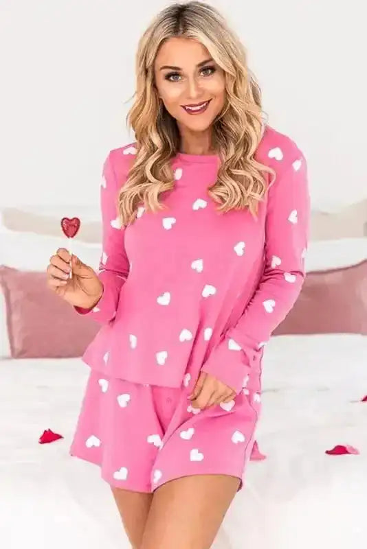 Model holding a heart-shaped lollipop while wearing Pink Valentine Lounge Set, a cute and cozy two-piece for Valentine’s Day.