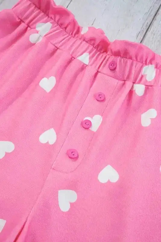 Close-up of button fly on Pink Valentine Lounge Set shorts, featuring white heart prints and elastic waistband for a snug fit.