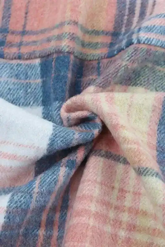 Textured fabric close-up of plaid shacket flap pockets, showing soft brushed polyester in pink, blue, and yellow tones.