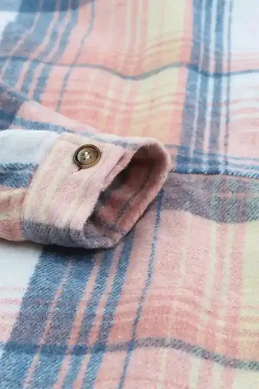 Cuff and sleeve button detail of stylish plaid shacket for fall fashion, featuring soft fabric and western-inspired pattern.
