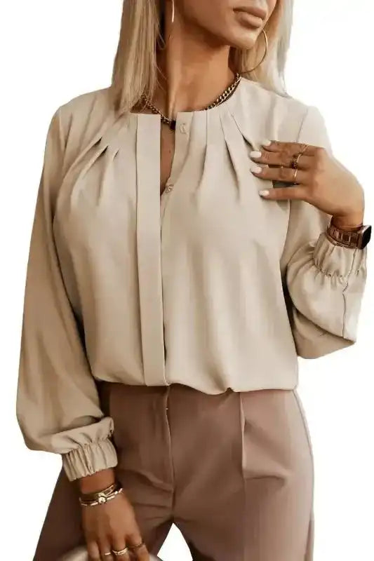 Front view of beige Pleated Neck Stretch Cuff Shirt with pleated neckline and stretch cuffs. A fashionable and comfy top.