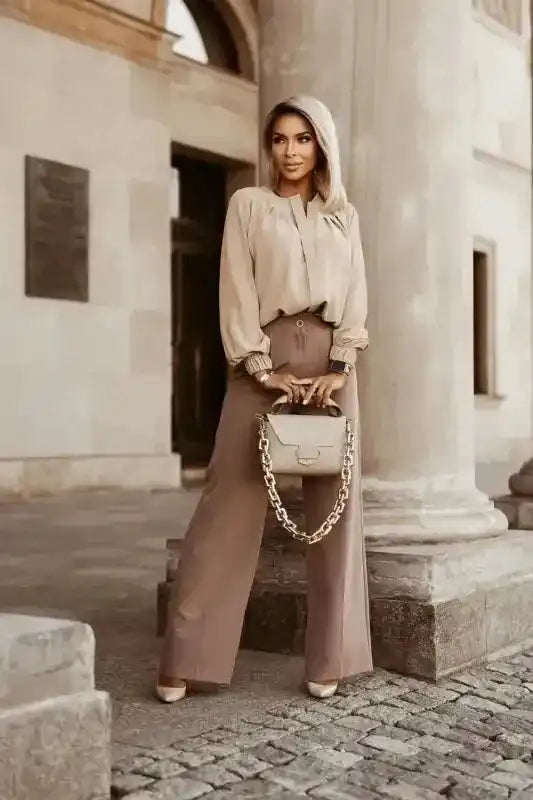 Full-body view of beige Pleated Neck Stretch Cuff Shirt with wide-leg trousers. A stylish fall outfit for women.