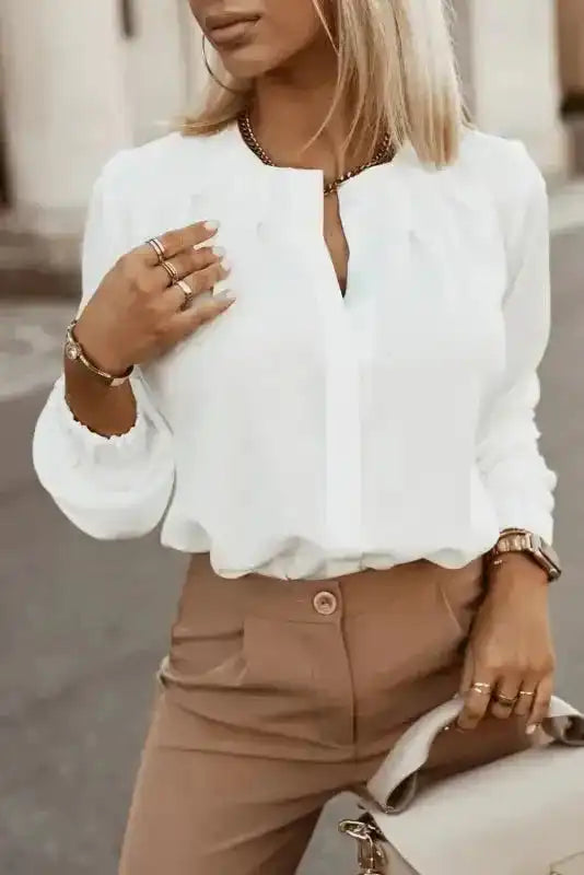 Close-up of white Pleated Neck Stretch Cuff Shirt with gathered cuffs and pleated neckline. A chic and elegant women's top.