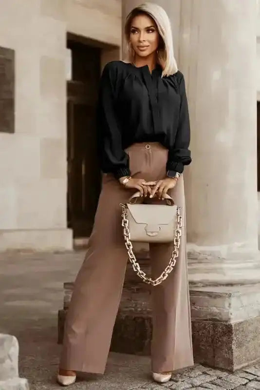 Full outfit featuring black Pleated Neck Stretch Cuff Shirt and wide-leg beige trousers. Stylish women's blouse for autumn wear.
