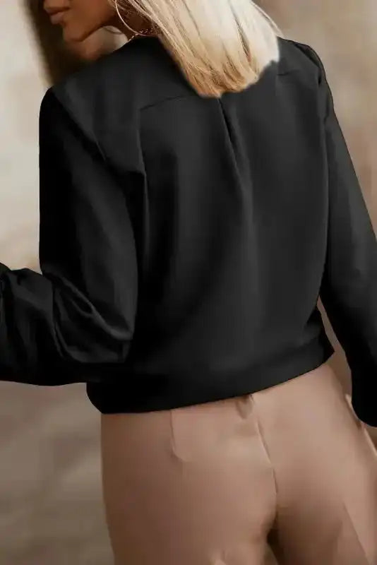 Back view of black Pleated Neck Stretch Cuff Shirt showing relaxed fit and long sleeves. Perfect for fall fashion layering.