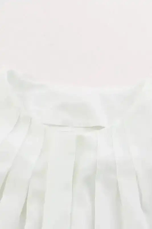 Close-up of pleated neckline on white Pleated Neck Stretch Cuff Shirt, highlighting elegant detailing for fall women's blouses.
