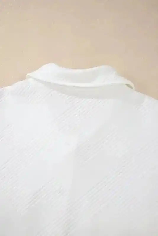 Close-up of back collar area on white textured plus size jacket, highlighting the subtle ribbed pattern and soft structure.