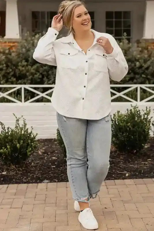 Full body view of plus size model in textured white jacket and jeans, showcasing a relaxed and stylish winter outfit.