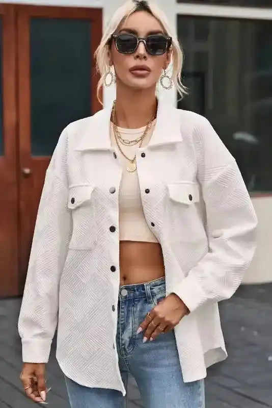Model opening a white textured plus size jacket to reveal a cropped top underneath, styled for casual winter outings.