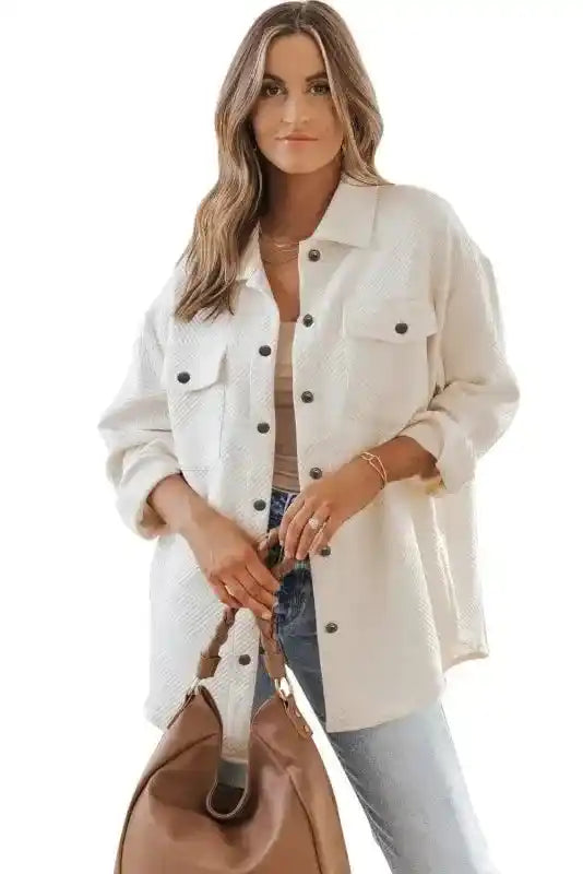 Woman modeling white plus size textured jacket with front pockets and snap buttons, styled for a relaxed winter look.