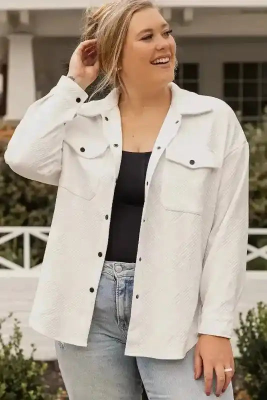 Textured plus size jacket in white with front snap buttons and chest pockets, styled casually with jeans for winter comfort and style.