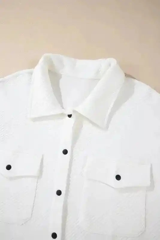 Close-up of collar and chest pockets on white textured plus size jacket, showcasing detailed ribbed fabric and button accents.
