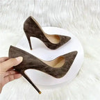 Hand holding brown suede stiletto pumps with pointed toe, highlighting the shoe's premium finish and sleek design.