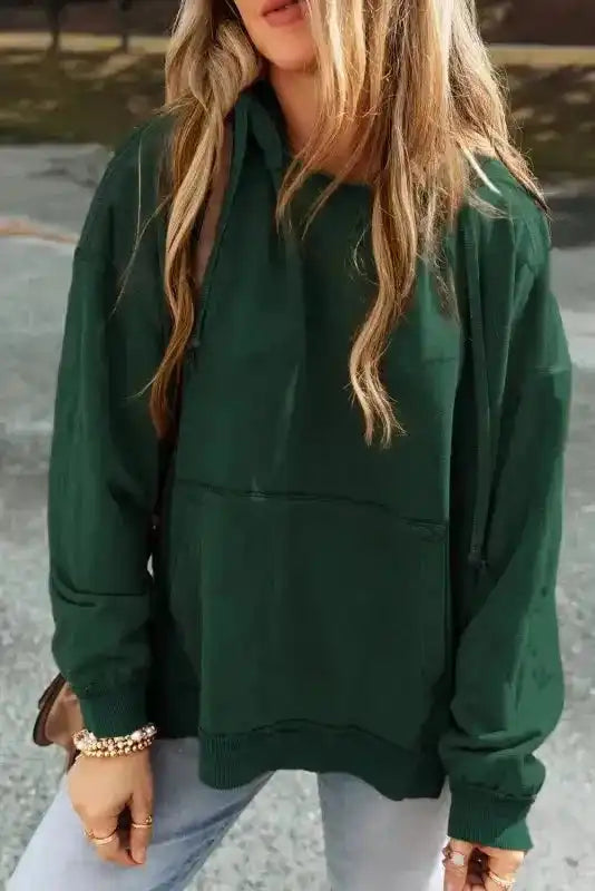 Dark green Exposed Seam Hoodie with quilted patchwork texture, front pocket, and oversized fit for stylish everyday comfort.