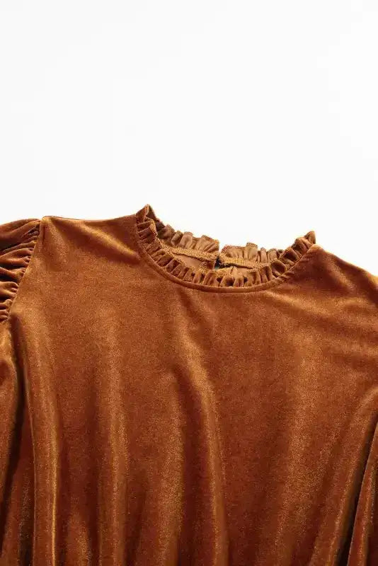 Close-up of frilled neckline and shoulder detailing on chestnut velvet swing dress, highlighting feminine design elements.