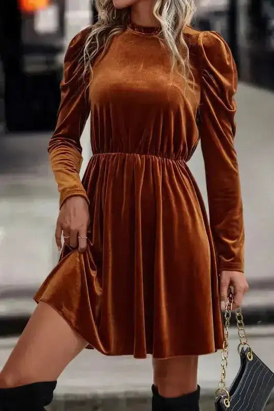 Elegant chestnut velvet mini dress with frilled neckline and long puff sleeves, styled for a night out or holiday event.