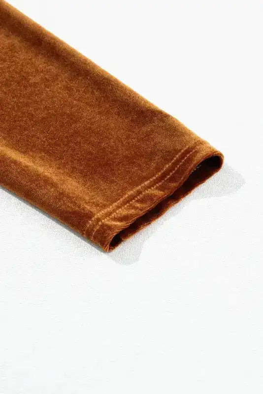 Detail of long sleeve hem on chestnut velvet swing dress, showcasing soft texture and quality stitching.