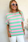 Woman in relaxed elegance tee with pink-green stripes and white sunglasses