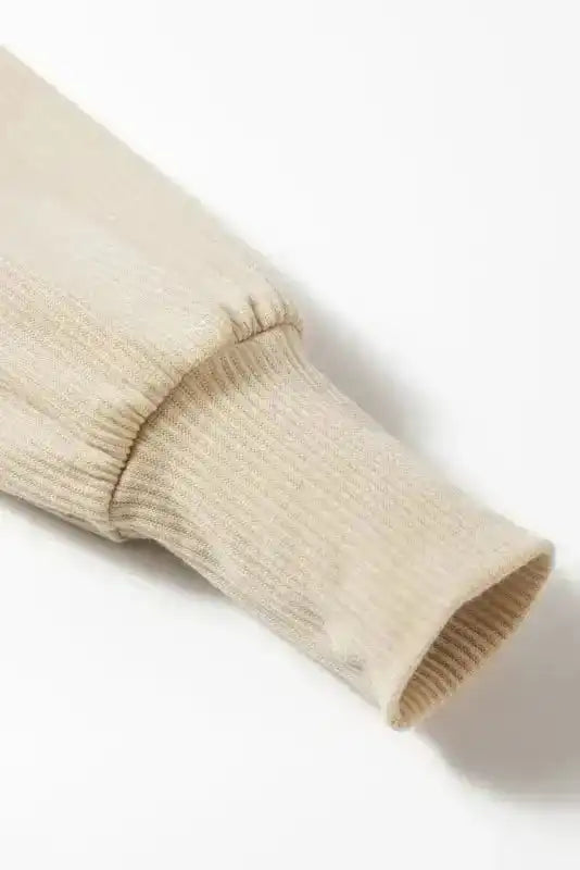 Detailed sleeve cuff of beige Ribbed Balloon Sleeve Bodysuit showing ribbed knit texture and elastic wrist design.