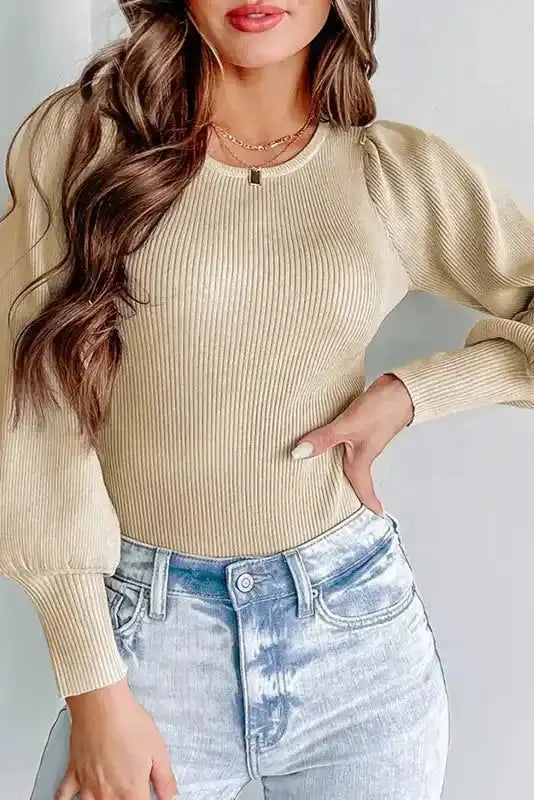 Beige Ribbed Balloon Sleeve Bodysuit with round neckline and fitted silhouette, styled with light-wash jeans for a chic daily look.