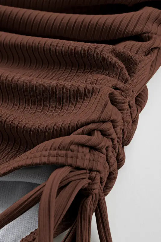 Close-up of gathered brown ribbed fabric for ribbed drawstring sides one piece swimsuit