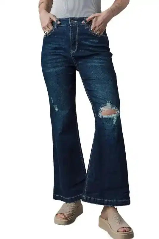 Model wearing Ripped Bell Bottom Jeans with distressed knees and flared legs, styled for a casual spring look.