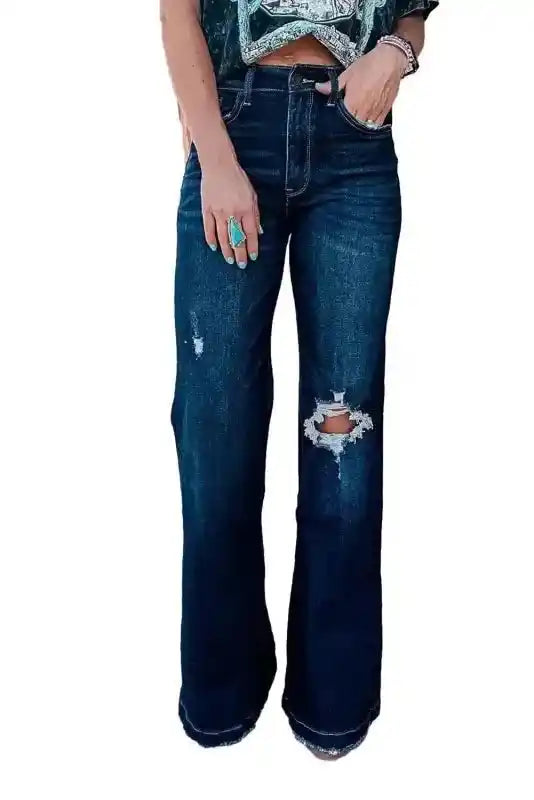 Isolated front view of Ripped Bell Bottom Jeans on white background, highlighting distressed knee and flare leg design.