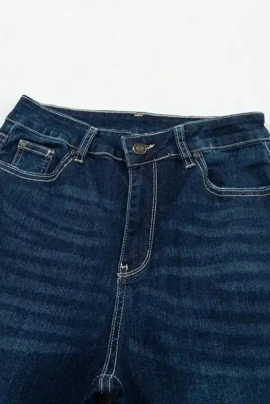 Top view of Ripped Bell Bottom Jeans highlighting front zipper, belt loops, and contrast stitching on dark wash denim.