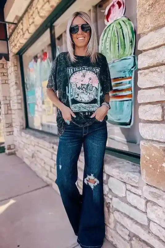 Model wearing Ripped Bell Bottom Jeans styled with a graphic tee, showcasing a trendy western streetwear look.