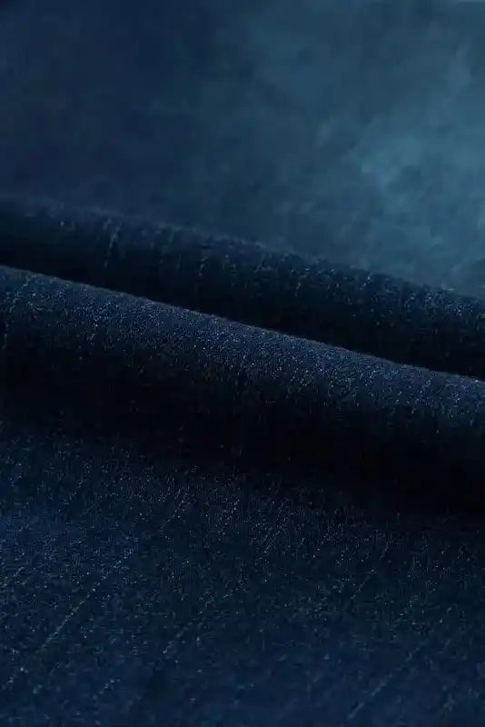 Close-up of dark blue denim fabric used in Ripped Bell Bottom Jeans, highlighting texture and quality.